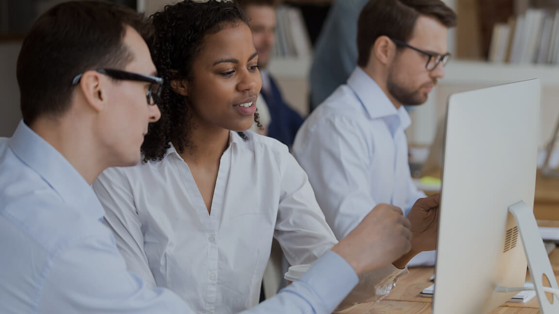 Mann und Frau vor einem Bildschirm sitzend
