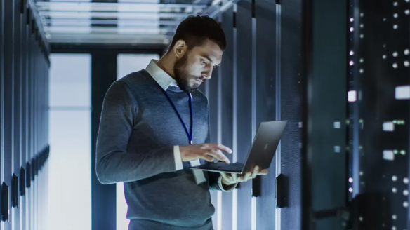 IT expert with a laptop in a server room